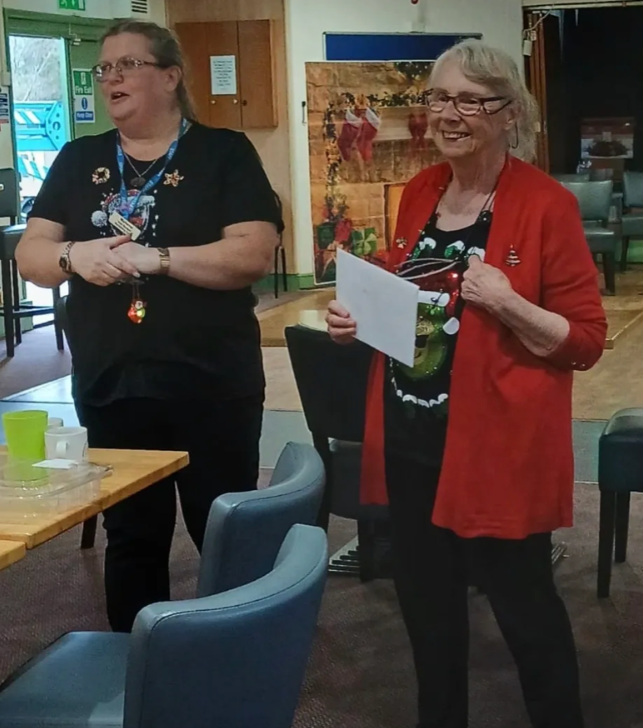Two volunteers presenting at a community Christmas event