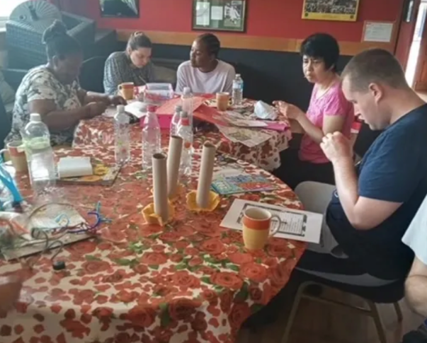 Group of people doing a craft activity around a table