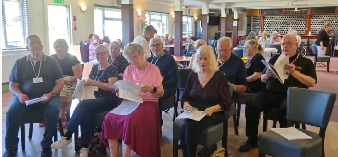 Large group of community members seated together at an indoor event