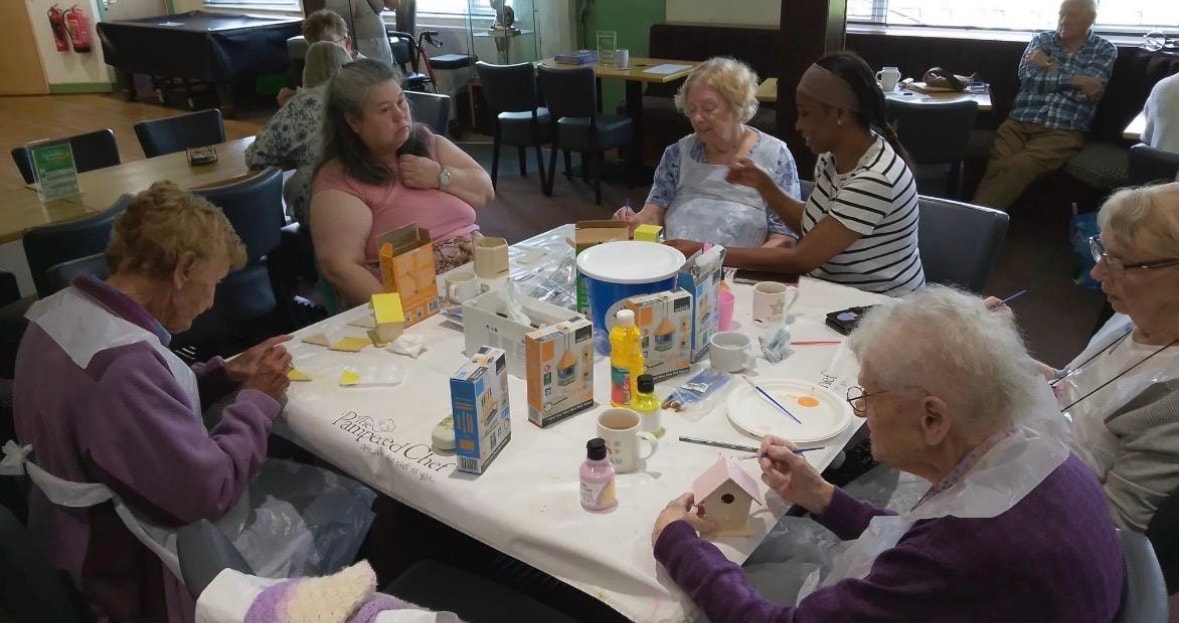 Seniors gathered around a table for a craft activity