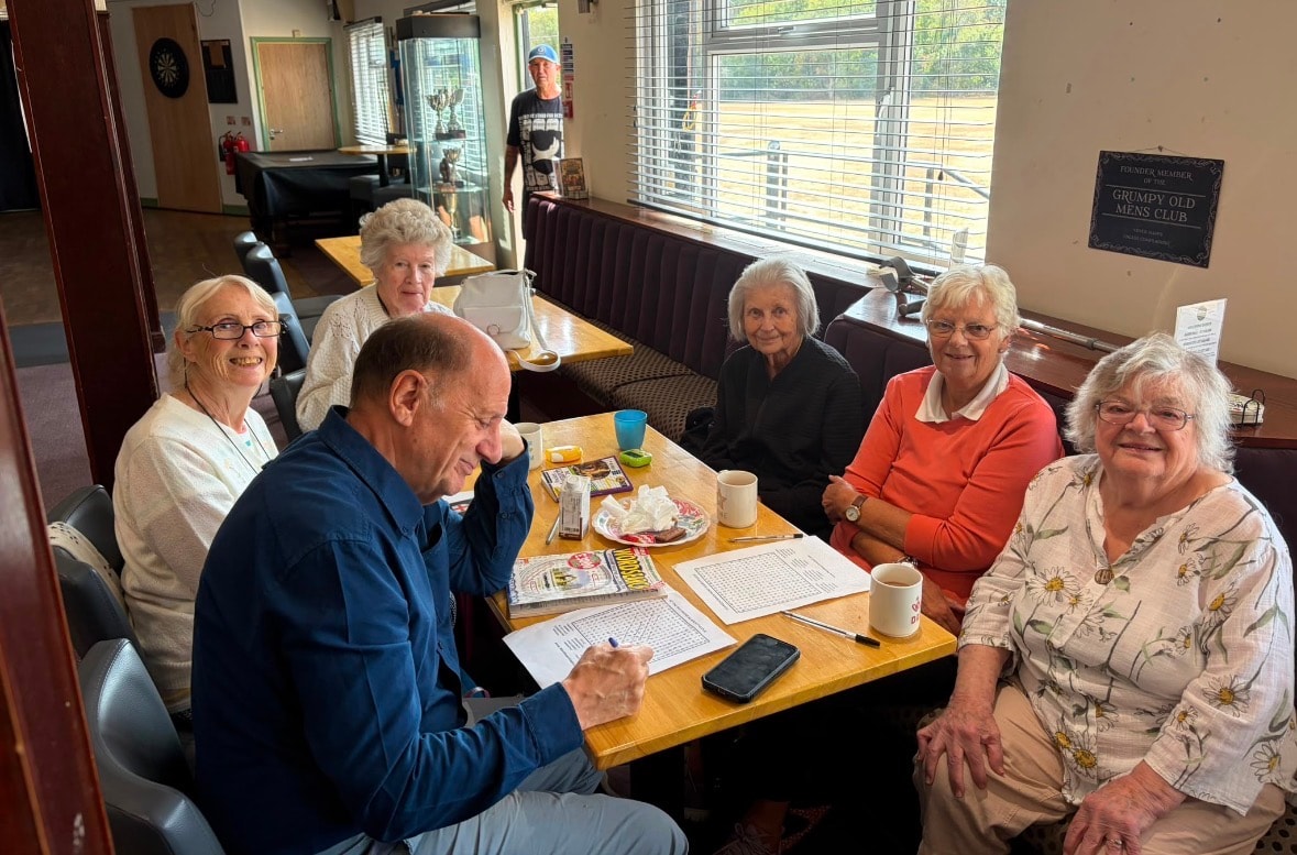 Mixed group of members enjoying puzzles and word searches together at a hub session