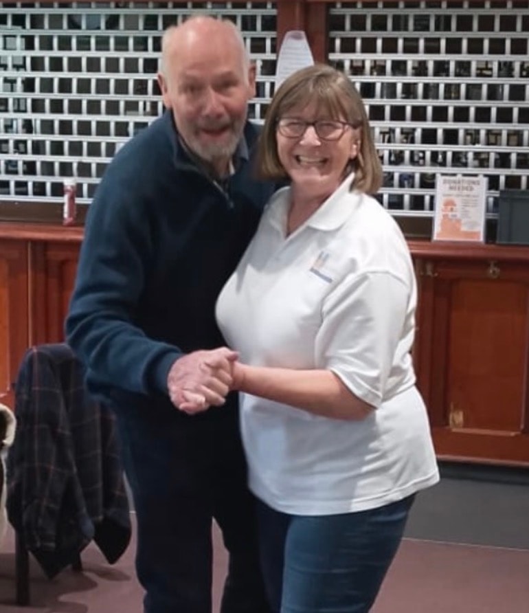 Two people dancing together at a community event