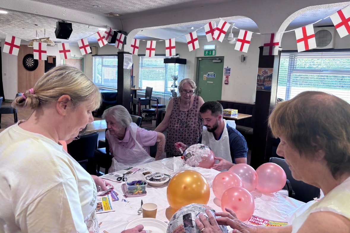 Members enjoying a craft activity session decorated with English flag bunting